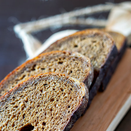 Slices of fresh grey bread on the wooden natural board. Healthy food concept. 