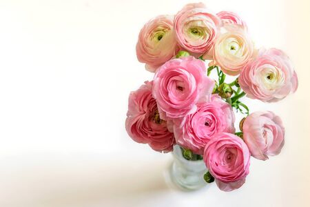 Bouquet of ranunculus or buttercup in the glass vase on the white background closeup, isolated, top view. Nice greeting card for MotherÂ´s day, WomenÂ´s day, St. ValentienÂ´s day or Easter. の写真素材