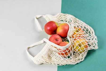 Red apples in the cotton string bag isolated closeup, top view. Healthy eating, ecological zero...