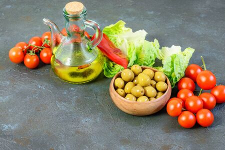 Light vegetables and olive oil bottle on the dark background. Balanced dietary products with vitamins and minerals. Healthy light lifestyle concept.の写真素材