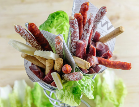 Assortment of tasty fuet and chorizo sausages, cheese and bread sticks in eco paper bag. Fast food, typical mediterranean. の写真素材