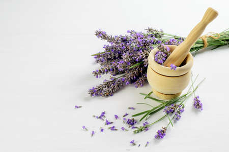 Lavender flowers on the white background and in the wooden mortar.の写真素材