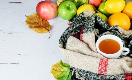 Fruit tea cup, warm scarf, citrus tropical fruits as symbols of antiviruses remedy, booster immune system.の写真素材