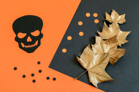 Decorative black scull, peas and golden maple leaves on the paper Halloween background. Nice design for greeting card or party invitation.の写真素材
