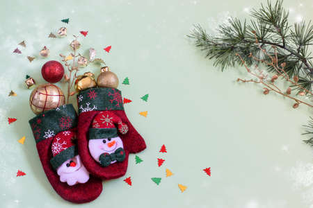 New Year mittens decorated with sparkle shiny balls, baubles and confetti. Christmas background, top view, flat lay photo.の写真素材