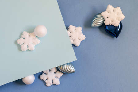 White snowflakes and balls, silver cones and baubles on the blue bicolor background. Nice trendy design for any card invitation, greetings or any your purposes.の写真素材
