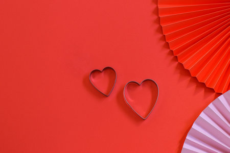 Two heart shapes on the red background with trendy paper fans.Nice card design for Sant Valentine's day or party invitation.の写真素材