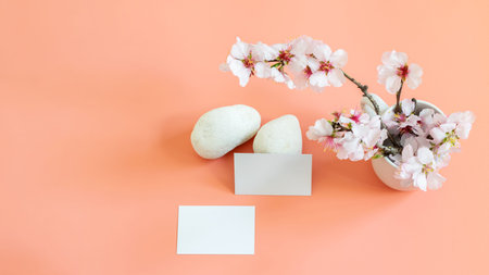 Spring mock up template with business cards, almond blooming branch and white stones. Pink banner...