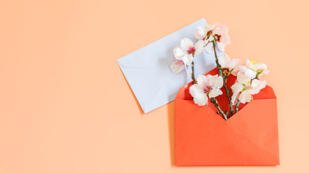 Mock up template with card blank and blooming almond branch in red envelope. Nice design for...