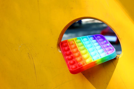 orange wall in the playground with Multicolored antistress pop it toyの写真素材