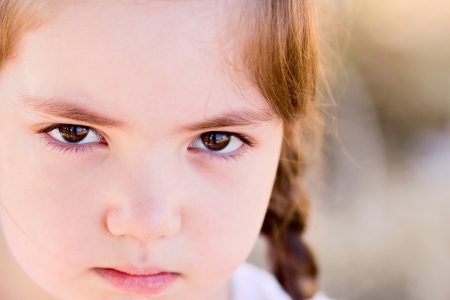 Portrait of angry little girl with serious eyesの写真素材