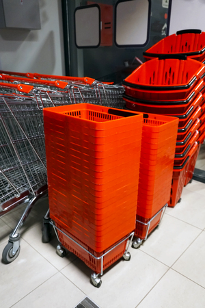 Rows of aligned shopping carts and red baskets.の写真素材