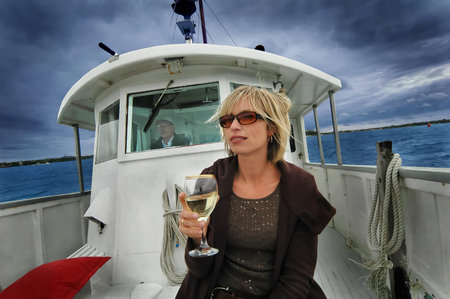 Blonde lady on boat enjoying white wine, Auckland, New Zealand