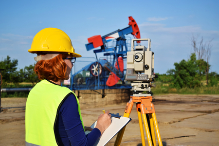 A female land surveyor engineer at work on an European petroleum wellの写真素材