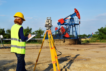 A female land surveyor engineer at work on an European petroleum wellの写真素材