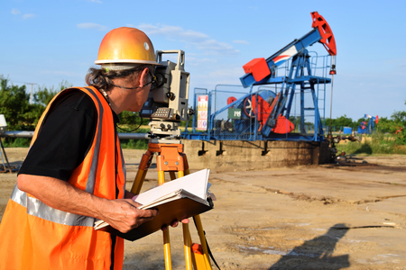 A male land surveyor engineer at work on an European petroleum wellの写真素材