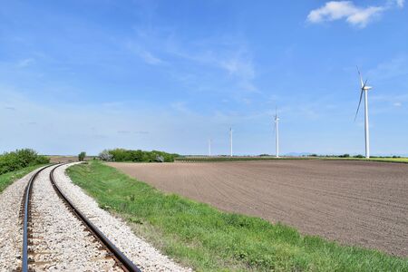 Railroad track perspective and wind farm Alibunar (Serbia) in backgroundの写真素材