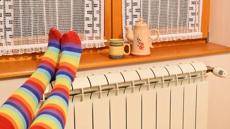 A woman in striped socks enjoying winter in a cozy, warm roomの写真素材