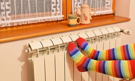 A woman in striped socks enjoying winter in a cozy, warm roomの写真素材