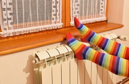 A woman in striped socks enjoying winter in a cozy, warm roomの写真素材