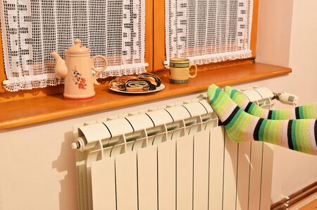 A woman in striped socks enjoying winter in a cozy, warm roomの写真素材