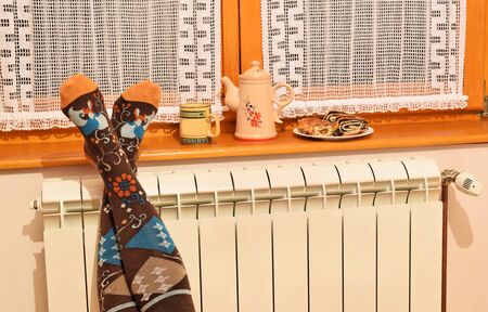 A woman in colorful socks enjoying winter in a cozy, warm roomの写真素材