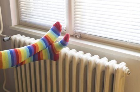 A woman in striped socks enjoying winter in a cozy, warm roomの写真素材