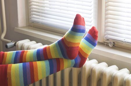 A woman in striped socks enjoying winter in a cozy, warm roomの写真素材