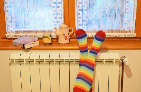 A woman in striped socks enjoying winter in a cozy, warm roomの写真素材