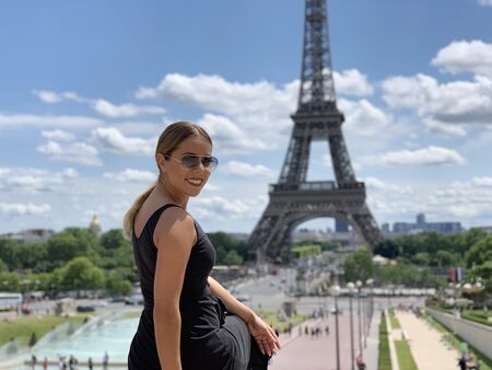 A female tourist in front of the Eiffel Tower, Paris, Franceの写真素材