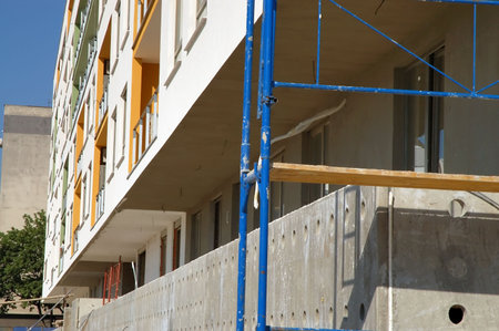 Scaffold on construction site of almost finished modern buildingの写真素材