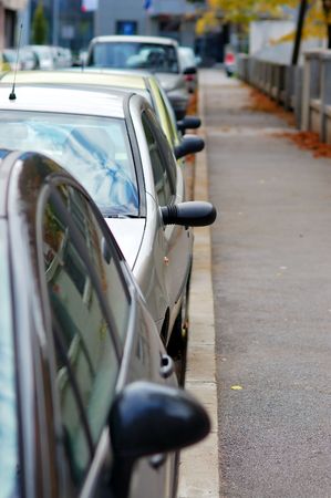 Street in European town with cars parked all overの写真素材