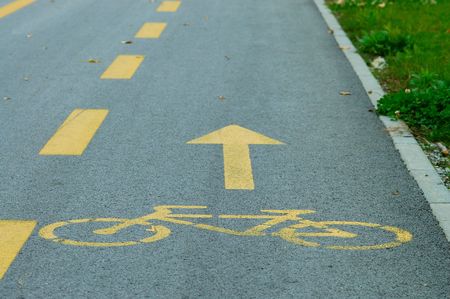 Yellow bike lane sign painted on streetの写真素材