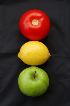 Concept of fruits representing traffic light on black background (red = stop, yellow = caution, green = go)の写真素材