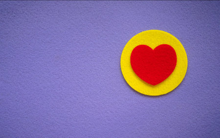 Red textile heart on a yellow circle and purple background. A postcard made of felt fabric. A place for romantic text on a purple background.の写真素材