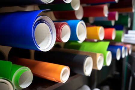 Shelf with rolls of self-adhesive film of different colors in production. Sale of materials for advertising.の写真素材