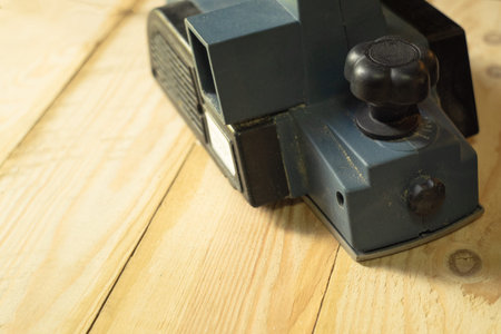Blue electric chopper on a light board. Wood processing with power tools.