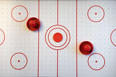 An air hockey field with red round handles. Top view. Active games for two players.の写真素材