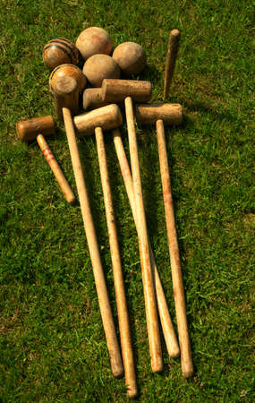 Antique croquet set. Wooden clubs with balls on the green grass.の写真素材