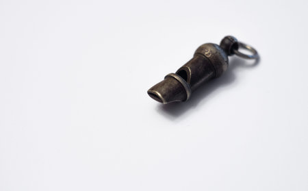 Antique bronze whistle on white isolate. A police whistle to signal.