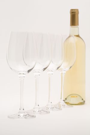 white wine bottle with wineglasses lined upの写真素材