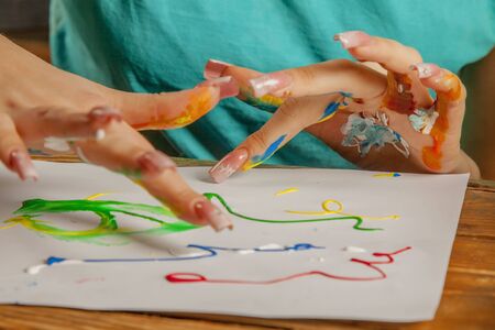 Close up beautiful young woman painting with fingerの写真素材