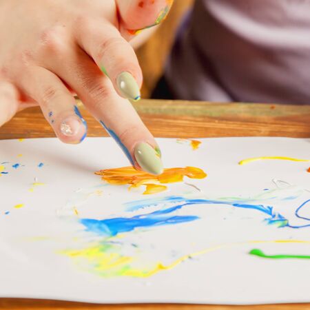 Art as psychological therapy for mental health. Young beautiful woman painting with fingers.  Selective focus.の写真素材