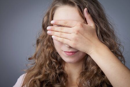 Love is blind. Portrait of beautiful young woman with heart before her eyes.の写真素材