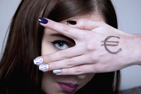 Young beautiful woman looking through fingers and hand drawn with money as a symbol of bribery, cheating, corruption, financial and l political manipulation. の写真素材