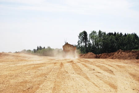 truck loaded with earth raising dustの写真素材