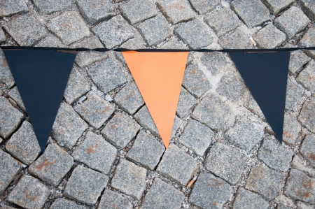 orange and blue empty triangular flags on the cobblestone floorの写真素材