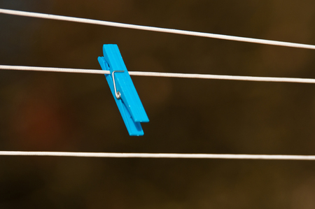 one blue clothespin hanging on a clotheslineの写真素材