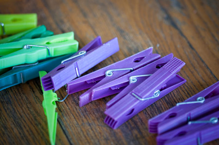 many colorful clothespins lying on a wooden garden table