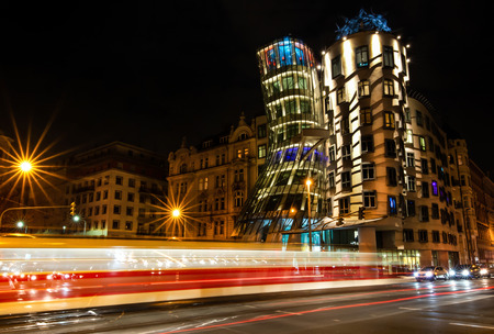 illuminated dancing house also called Ginger and Fred at night in Prague - tramway with long exposure time in the foregroundのeditorial素材